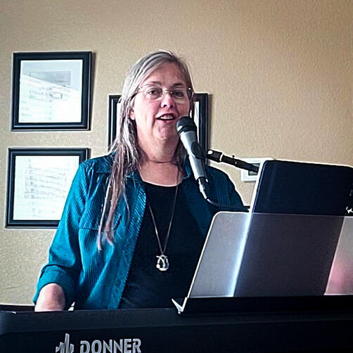 Connecting with residents at a local assisted living center Ronautta Wilson singing and playing piano at an assisted living center
